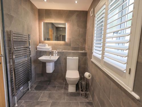 a bathroom with a toilet and a sink at Beech Lea in Ulverston