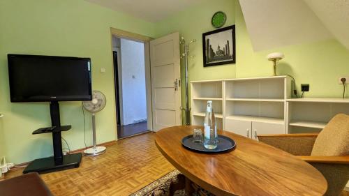ein Wohnzimmer mit einem Tisch und einem TV. in der Unterkunft Große Ferienwohnung mit Loggia und Garten in Cottbus (direkt am Klinikum) in Cottbus