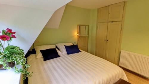 ein Schlafzimmer mit einem Bett und einer Vase aus Blumen in der Unterkunft Große Ferienwohnung mit Loggia und Garten in Cottbus (direkt am Klinikum) in Cottbus