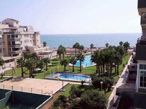 a view of a resort with a swimming pool and the ocean at Apartamento primera linea de Playa. Wifi in Retamar