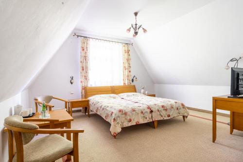 a bedroom with a bed and a chair and a window at Willa Bór in Zakopane