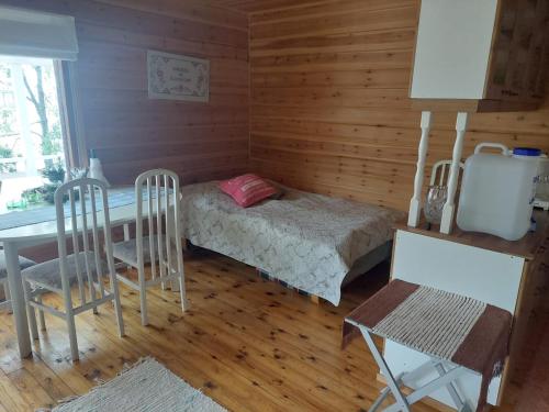 a small room with a bed and a table and chairs at Lakeside Lea, rantamökki 