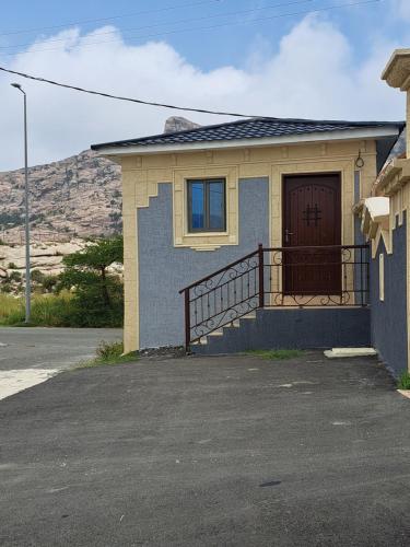 dom z brązowymi drzwiami i balkonem w obiekcie استوديو ريفي تنومه w mieście Tanomah