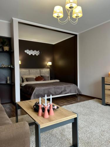 a bedroom with a bed and a table with candles at Центр. Острозького. Цум. 2 кімнати in Ternopilʼ