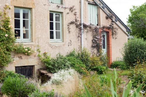an old house with ivy on the side of it at Maison de vacances Les Mésanges, à Ménessaire in Ménessaire