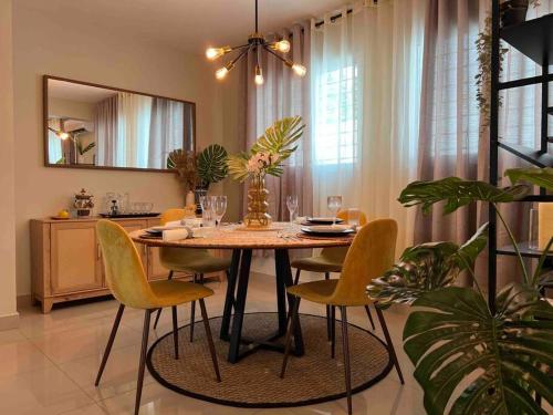 a dining room table with yellow chairs and a mirror at Modern luxurious apartment in Santiago de los Caballeros