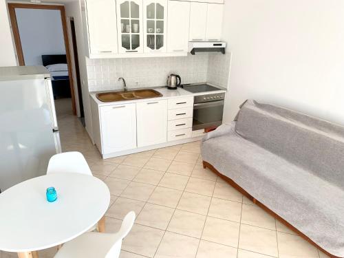 a kitchen with a couch and a table and a sink at Villa Saral Mar in Sarandë