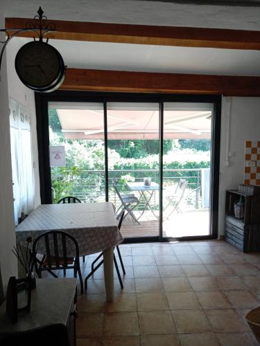 une cuisine avec une table et une horloge au mur dans l'établissement Maison sur la rivière, à Lasalle