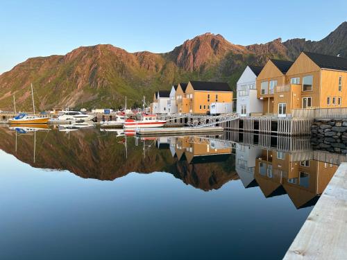 a marina with houses and boats in the water at The Modern Fisherman Cabin Lofoten in Ballstad