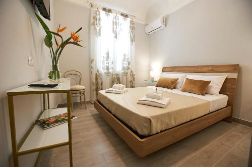 Un dormitorio con una cama y un jarrón con toallas. en Arbarìa, en Marsala