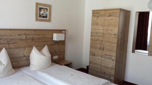 a bedroom with a bed and a wooden headboard at Hotel Alte Krone in Tübingen