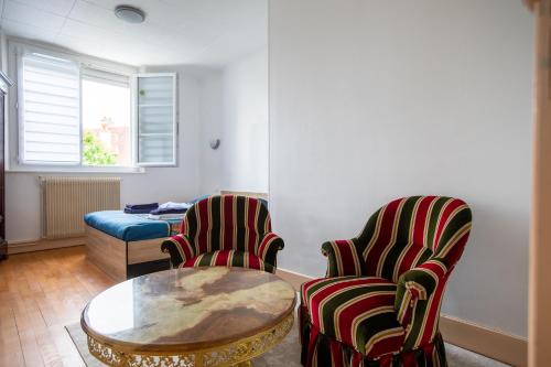 un salon avec deux chaises et une table dans l'établissement Le coquet chez Maguy Maison de ville avec jardin, à Besançon