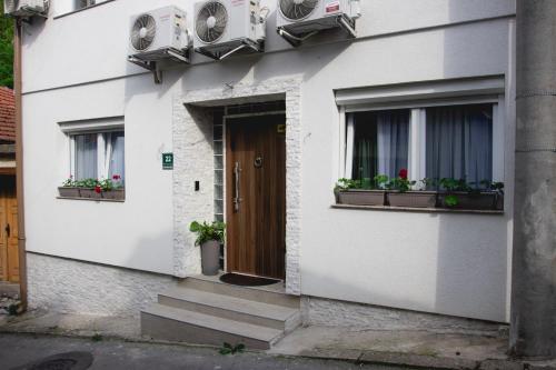 a white building with two windows and a door at Apartments HAN 2 Sarajevo in Sarajevo