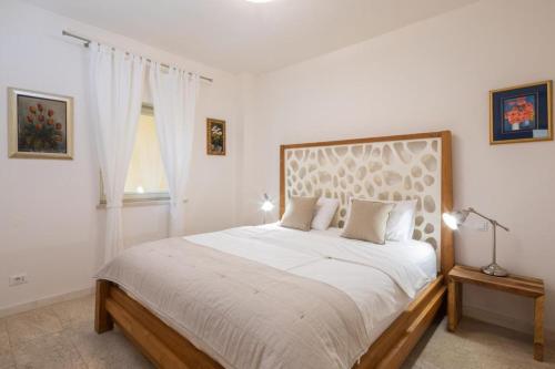 a white bedroom with a large bed and a window at Villa Fora Hvar in Hvar
