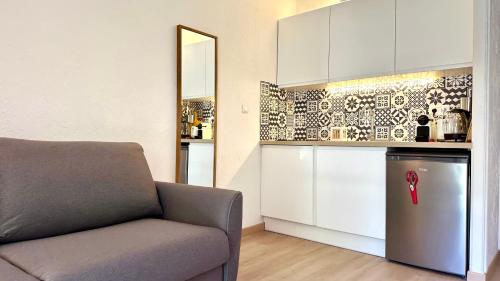 un salon avec un canapé et une cuisine dans l'établissement Studio climatisé avec piscine-tennis-parking, à Villeneuve-Loubet