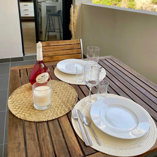 - une table avec des assiettes, des verres et une bouteille de vin dans l'établissement Parking gratuit grande terrasse Proche Centre Ville, à Ajaccio