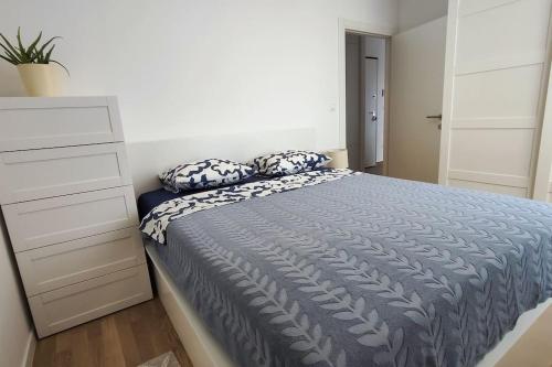a bedroom with a bed with pillows and a dresser at Salona Garden Apartman in Solin