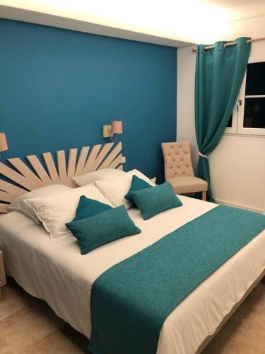 une chambre avec un grand lit avec un mur bleu dans l'établissement Villa CARIOCA St Tropez, à Saint-Tropez