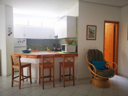 een keuken met een aanrecht en een aantal stoelen. bij Caparica Lounge & Terrace in Costa da Caparica