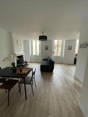 a living room with a table and a couch at Appartement1 neuf climatisée in Blaye