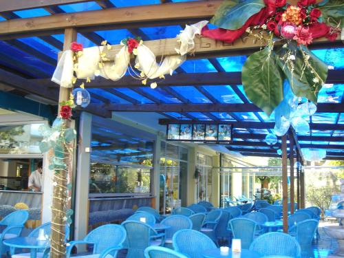 una habitación llena de sillas azules y mesas con flores en Hotel Da Giovanna, en Lignano Sabbiadoro