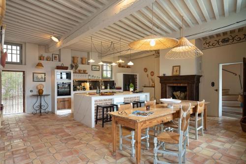 eine Küche mit einem Holztisch und einem Esszimmer in der Unterkunft La Maison Rimbert in Pernes-les-Fontaines
