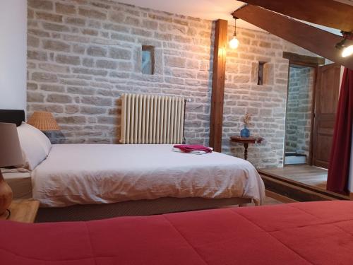 1 dormitorio con 2 camas y pared de ladrillo en 2 chambres privées au calme à la Maison des Bambous en Dijon