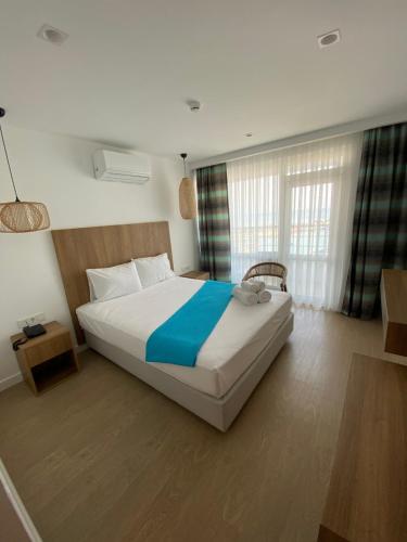 Finike Marina Hotel في فينيقيه: غرفة نوم بسرير كبير مع بطانية زرقاء