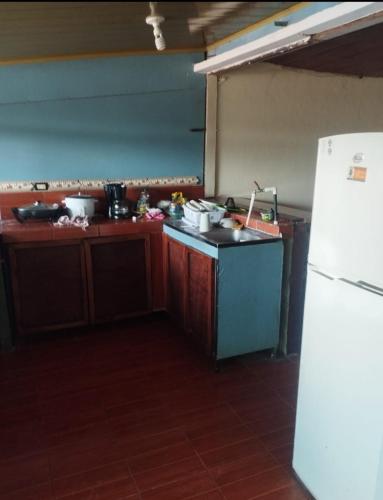 a kitchen with a sink and a refrigerator in it at Atardeceres in Puntarenas