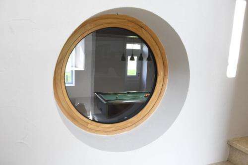 a round mirror on a wall with a pool table at Gîte moulin de Chaussac proche du Puy duFou in Saint-Laurent-sur-Sèvre