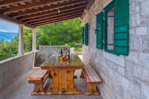 a wooden table and benches on a patio at Vacation House, PARKING INCLUDED, Lovrecina in Postira