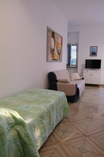 uma sala de estar com uma cama e um sofá em Valle dei Greci Rooms em Peschici