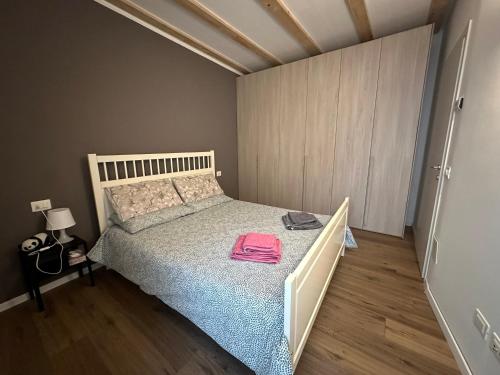 ein Schlafzimmer mit einem Bett und einem rosa Handtuch darauf in der Unterkunft Il nido in centro in Rovereto