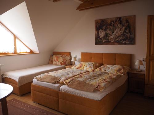 a bedroom with two beds and a painting on the wall at Privat Alenka in Liptovský Mikuláš