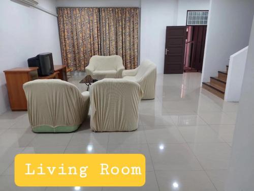 a living room with two white chairs and a tv at Sibu wawasan no.1 Homestay in Sibu