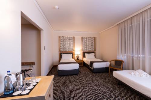 a hotel room with two beds and a desk at Hotel Mundial in Lisbon