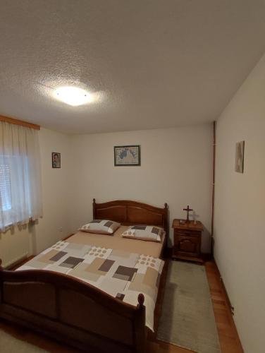 Un dormitorio con una cama y una mesa. en Barišić, en Livno