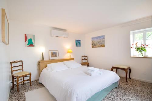 um quarto com uma grande cama branca e uma janela em Maison de vacances Les Mésanges, à Ménessaire em Ménessaire