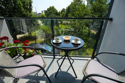 a balcony with a table with two cups of tea on it at Apartman Plaža 2 in Kladovo
