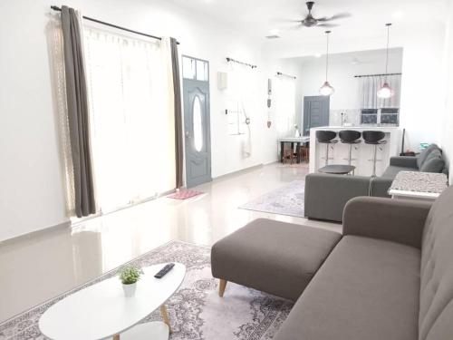 ein Wohnzimmer mit einem Sofa und einem Tisch in der Unterkunft Homestay Tok Kah in Kuala Terengganu