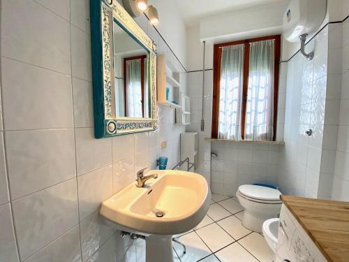 サン·ヴィンチェンツォにあるAppartamento il Leccioのバスルーム(洗面台、トイレ、鏡付)