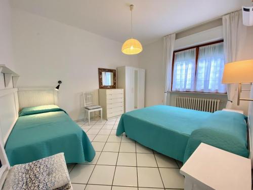 サン·ヴィンチェンツォにあるAppartamento il Leccioのベッドルーム1室(ベッド2台、窓付)