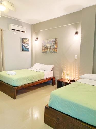 um quarto com duas camas e duas mesas de cabeceira em Green Oasis Hotel em La Romana