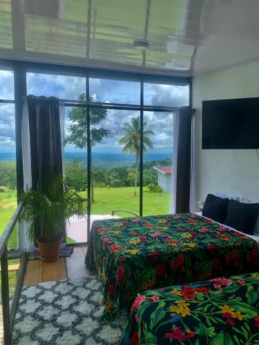 a bedroom with two beds and a large window at Villa Aura in Fortuna