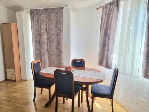 a dining room with a wooden table and chairs at Apartmani Prelević in Kamenovo