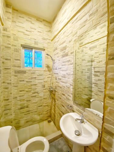 Green Oasis Hotel في لا رومانا: حمام به مرحاض أبيض ومغسلة