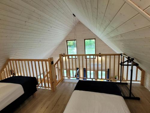 a room with a bed and a staircase in a attic at Kemping nad stawem in Harsz
