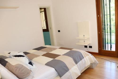 a bedroom with a bed with a checkered blanket at Appartement Dans un Terrain de Golf, 5 min de la mer en Voiture, Parking Gratuit in Cogoleto