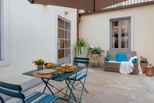 un patio con tavolo, sedie e divano di Il Cortile di Elisa & our flats a Lucca