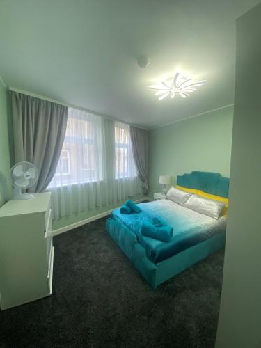 a bedroom with a blue bed and a window at Jackson Holiday Apartments in Blackpool